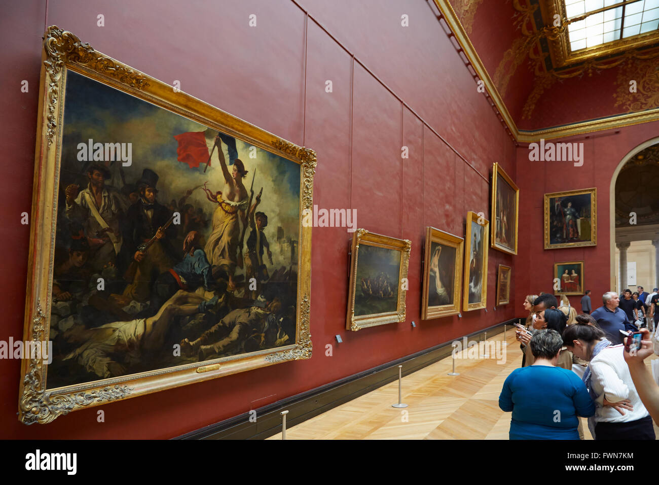 Freiheit führt das Volk von Eugène Delacroix im Louvre in Paris mit Besuchern Stockfoto