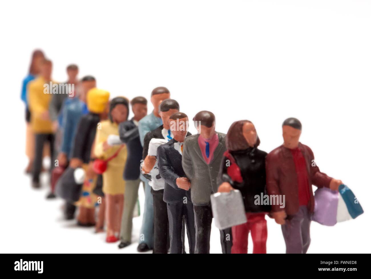 Miniatur Figur Menschen bilden eine geordnete Warteschlange vor einem weißen Hintergrund Stockfoto