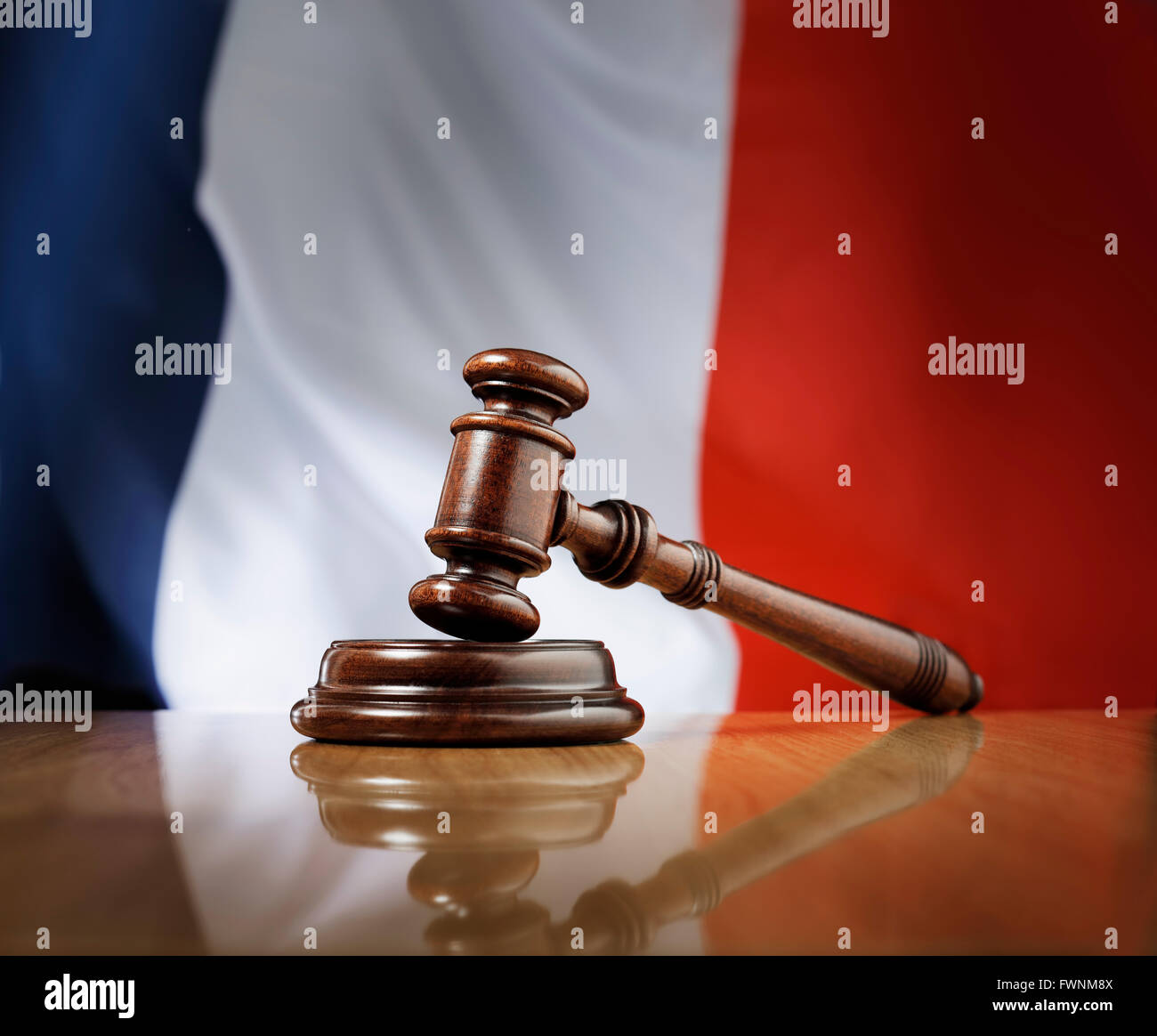 Mahagoni Holz Hammer auf glänzende Holztisch, Flagge von Frankreich im Hintergrund. Stockfoto