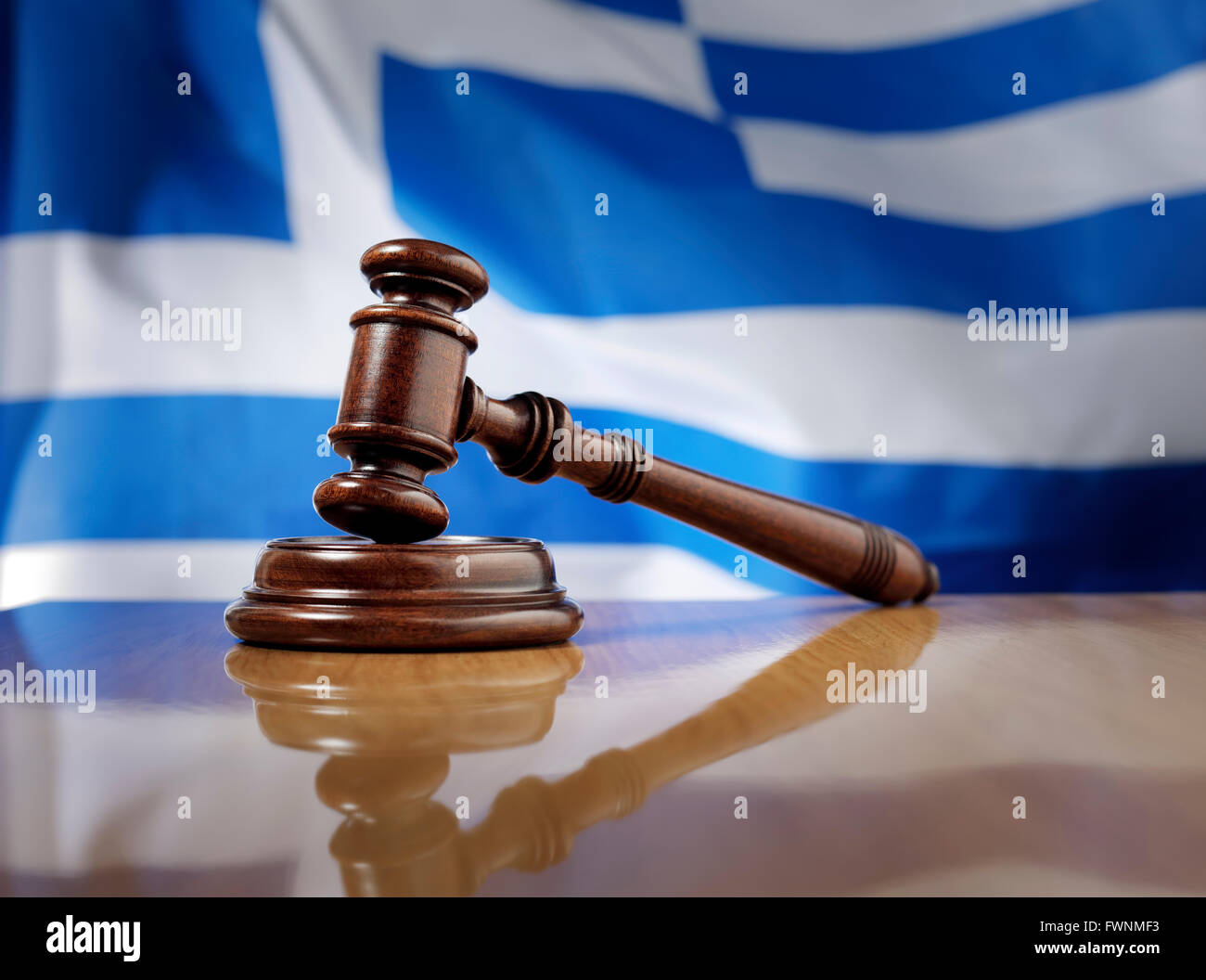Mahagoni Holz Hammer auf glänzende Holztisch, Flagge von Griechenland im Hintergrund. Stockfoto