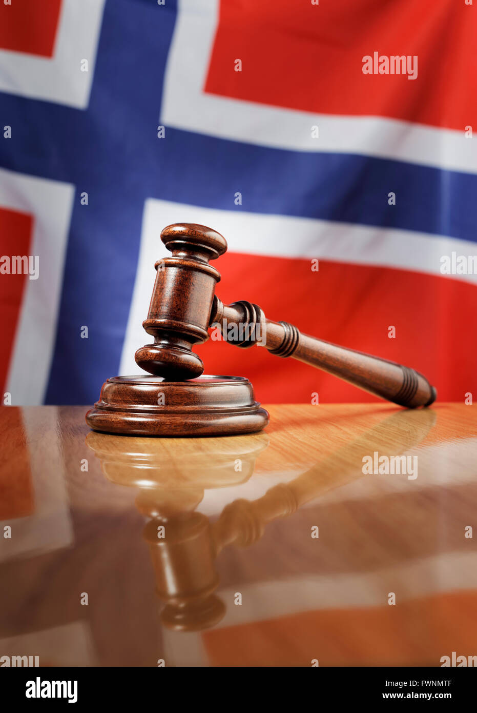 Mahagoni Holz Hammer auf glänzende Holztisch, Flagge Norwegens im Hintergrund. Stockfoto