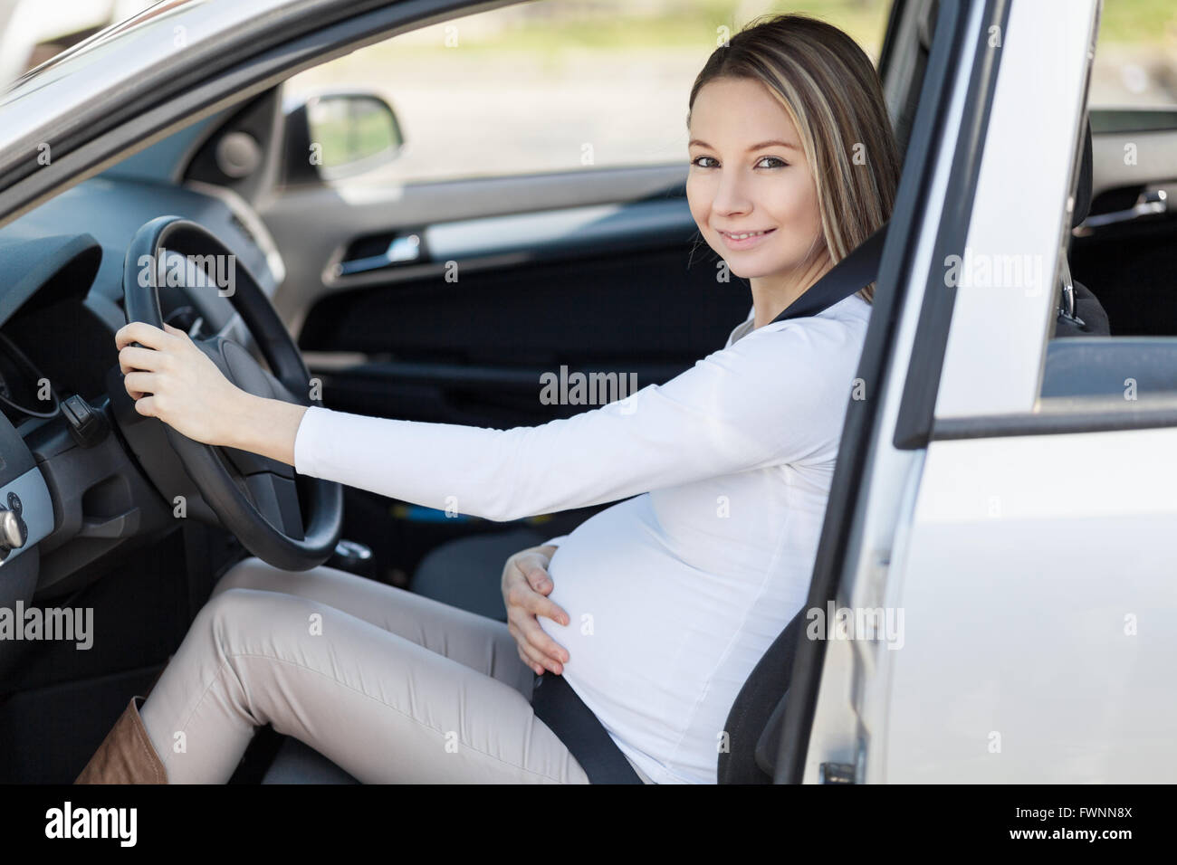Schwangere Frau ihr Auto Sicherheitsgurt tragen Stockfotografie