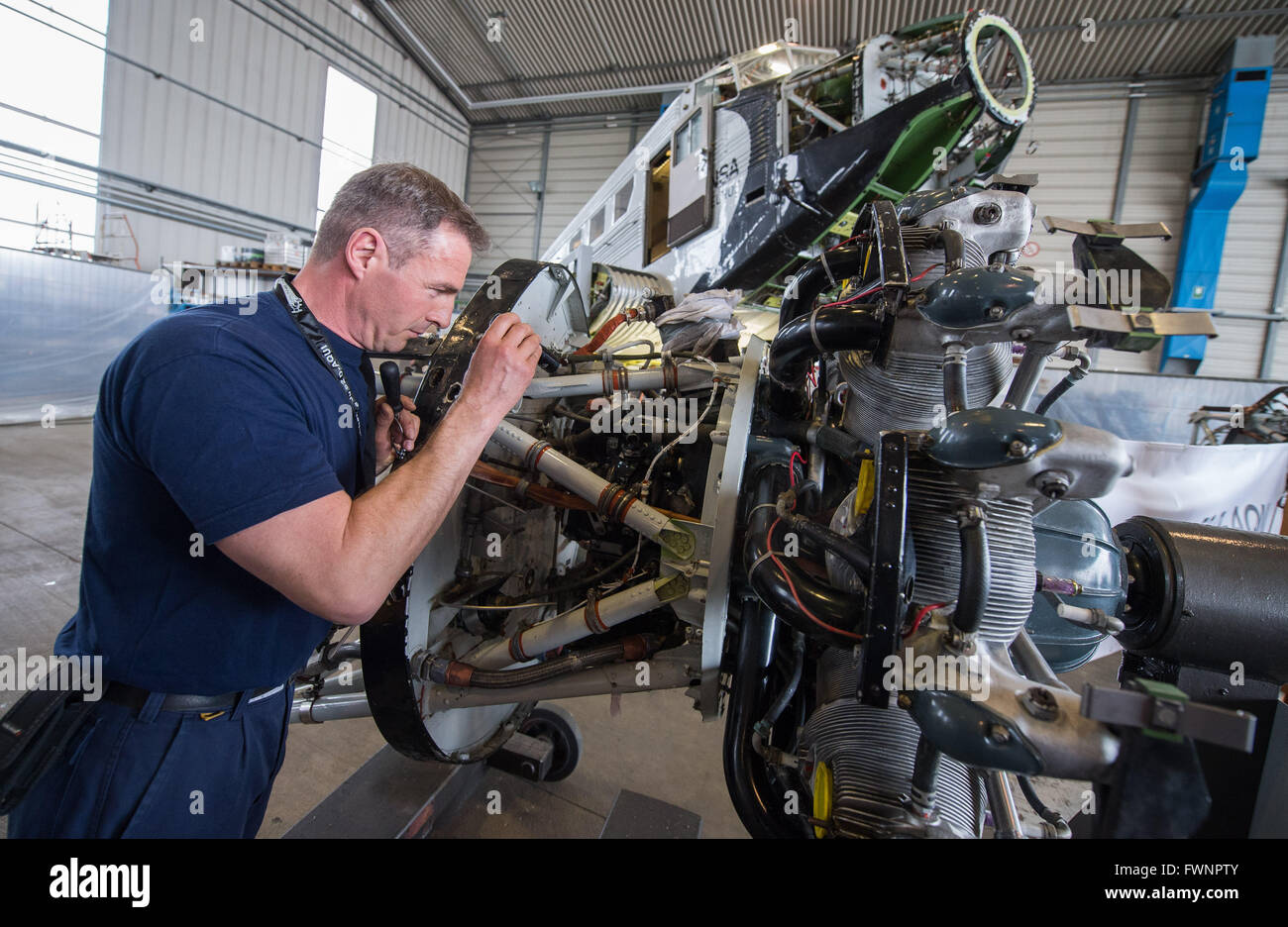 Hamburg, Deutschland. 6. April 2016. Mechaniker Sven Richter arbeiten am  Motor der Junker Ju 52 in einer Halle auf dem Gelände der Lufthansa Technik  in Hamburg, Deutschland, 6. April 2016. Das Flugzeug