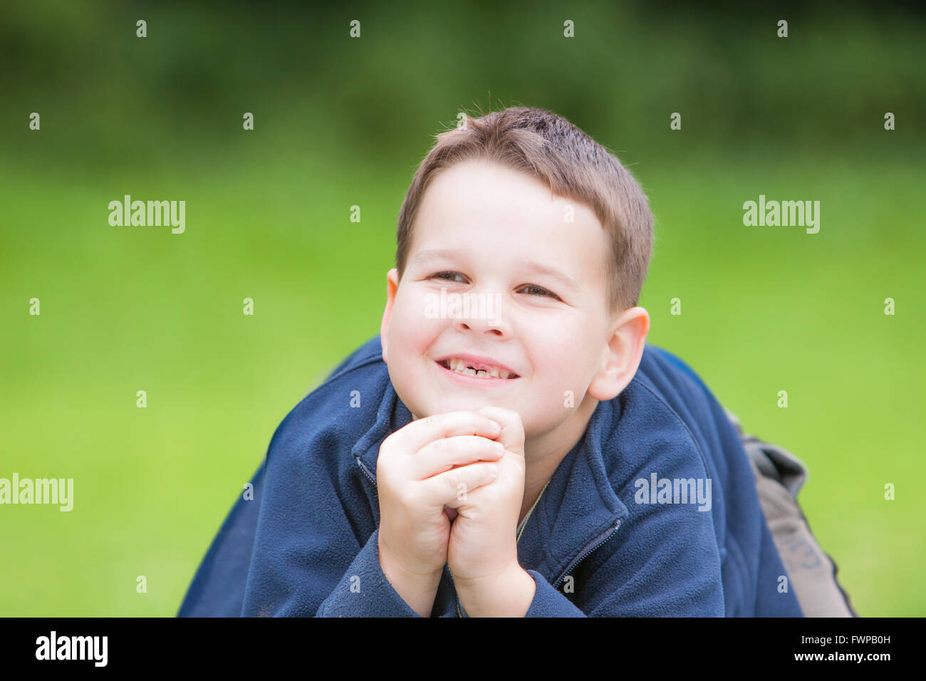 kleiner Junge mit einer zerrissenen vorderen ersten Milchzahn Stockfoto