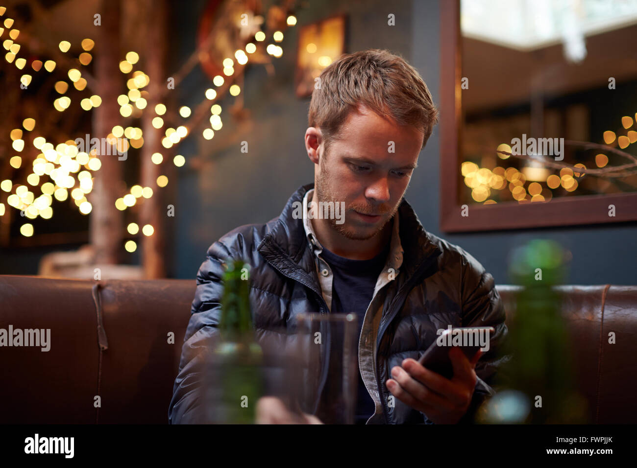 Mann sitzt im Cafe SMS Stockfoto