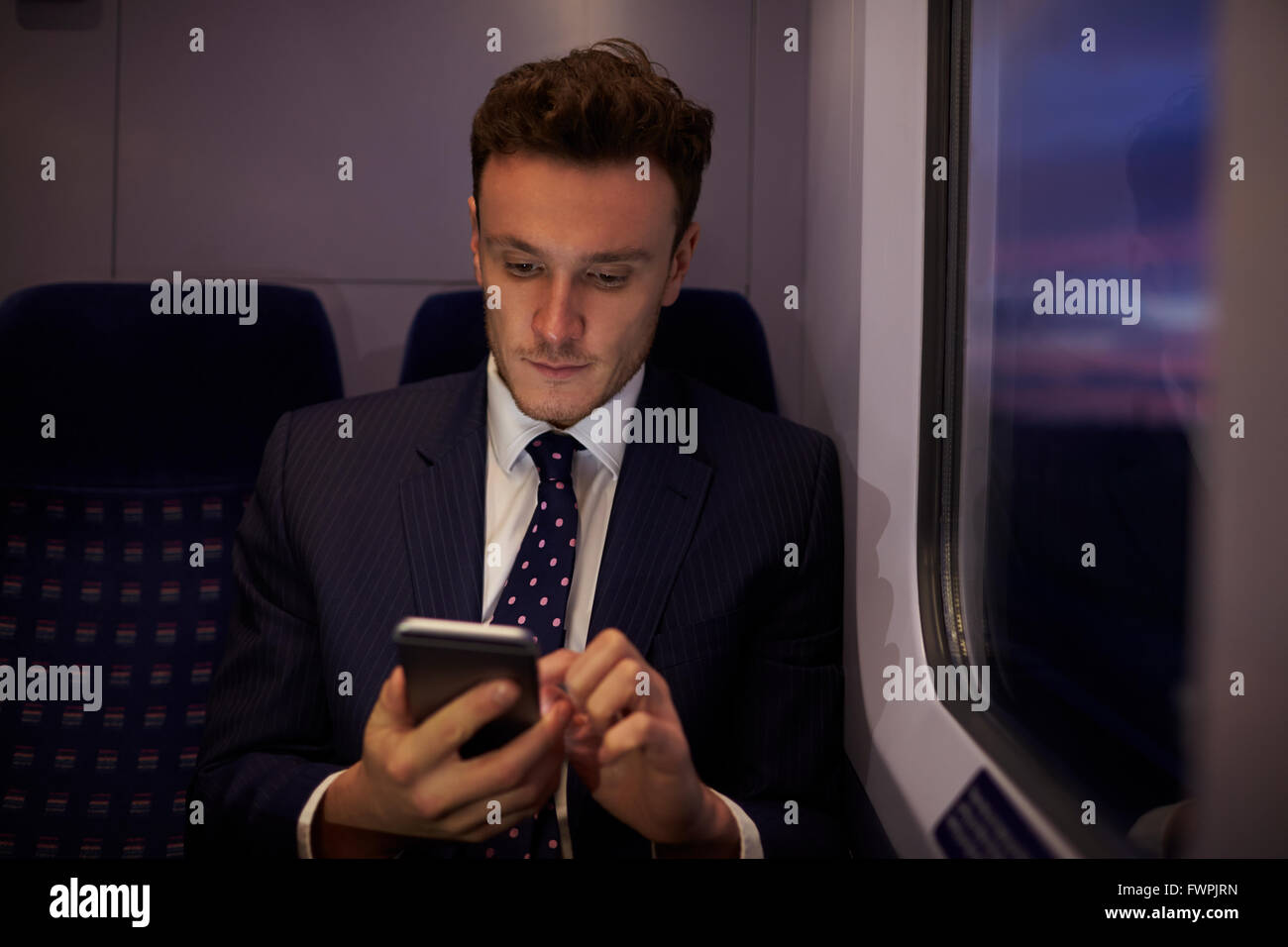 Geschäftsmann, sitzen im Zug Wagen senden SMS Stockfoto