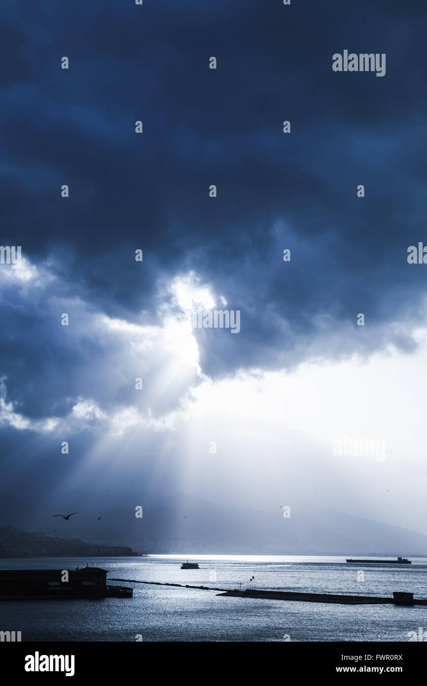 Dunklen dramatischen Himmel mit Wolken und Sonnenstrahlen über Meer. Blau getönten Foto-Filter-Effekt Stockfoto