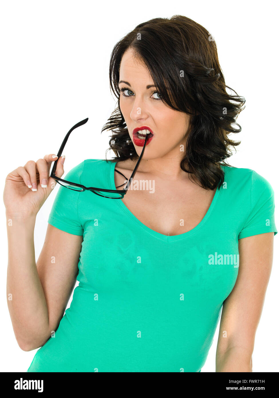 Junge Frau beißen zum Jahresende ihre Brille vor einem weißen Hintergrund isoliert Stockfoto