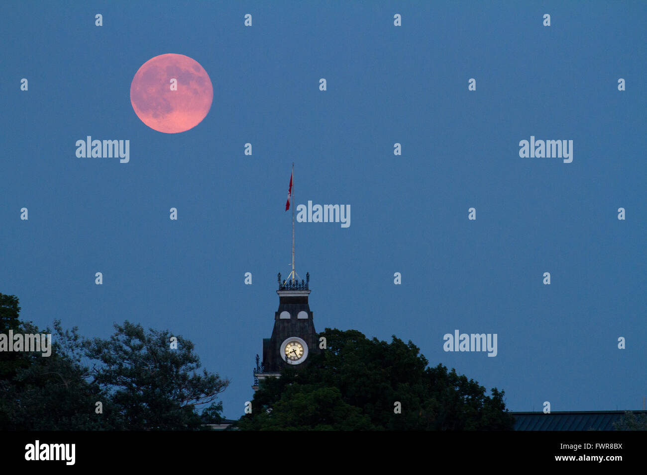 Der super Mondaufgang über der Uhrturm am Royal Military College of Canada in Kingston, Ontario, am 10. August 2014. Stockfoto