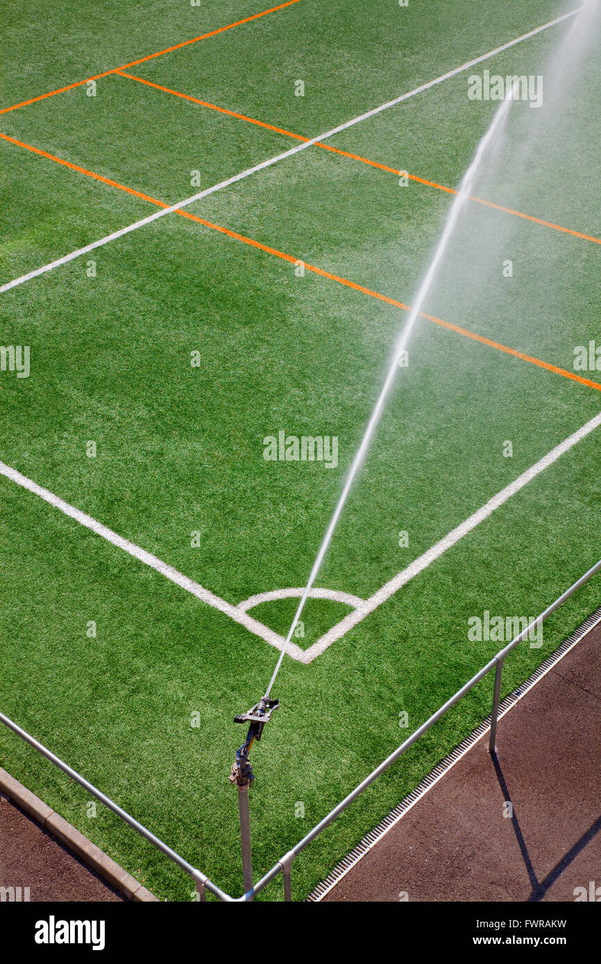 Bewässerung-Maschine arbeitet auf einem Fußballfeld grün. Stockfoto