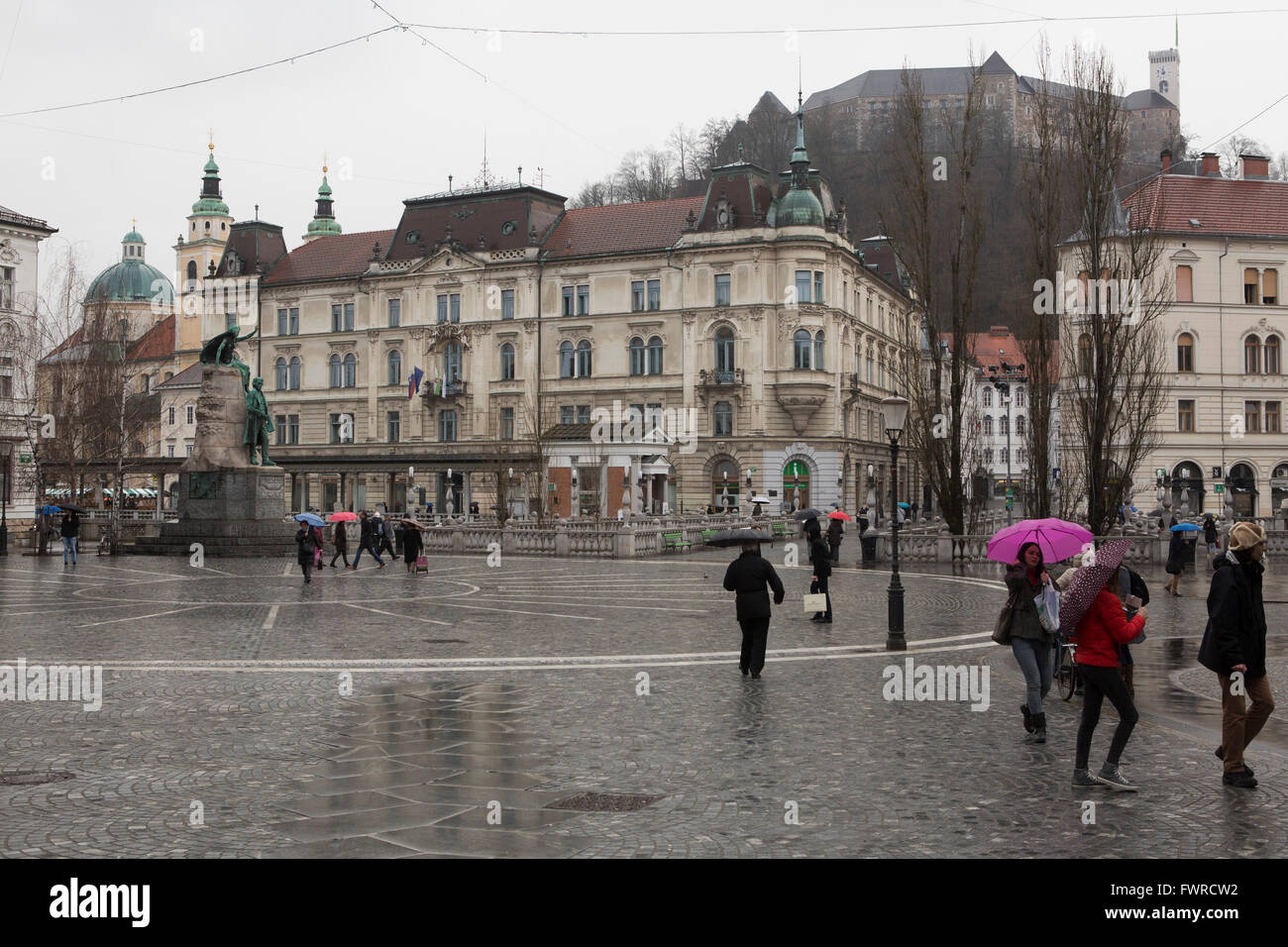 Ein Regentag auf Preseren-Platz in Ljubljana, Slowenien. Die Prager Burg steht auf dem Hügel im Hintergrund. Stockfoto