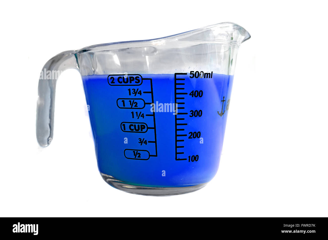 Blaue farbige Flüssigkeit in einer Pyrex Messung Krug vor weißem Hintergrund fotografiert. Stockfoto