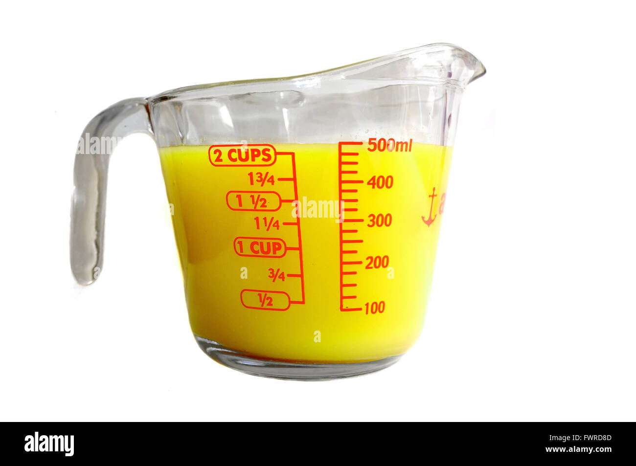 Ein Pyrex Messung Krug voller gelb gefärbten Flüssigkeit vor weißem Hintergrund fotografiert. Stockfoto