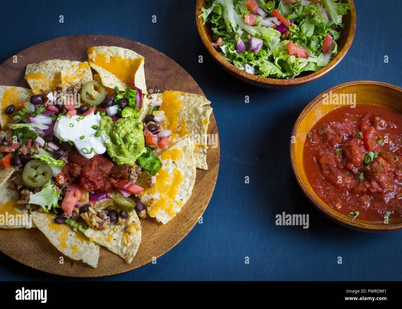 Nacho Käse-Tortilla-Chips mit Chili, Salsa, Sauerrahm und guacamole Stockfoto