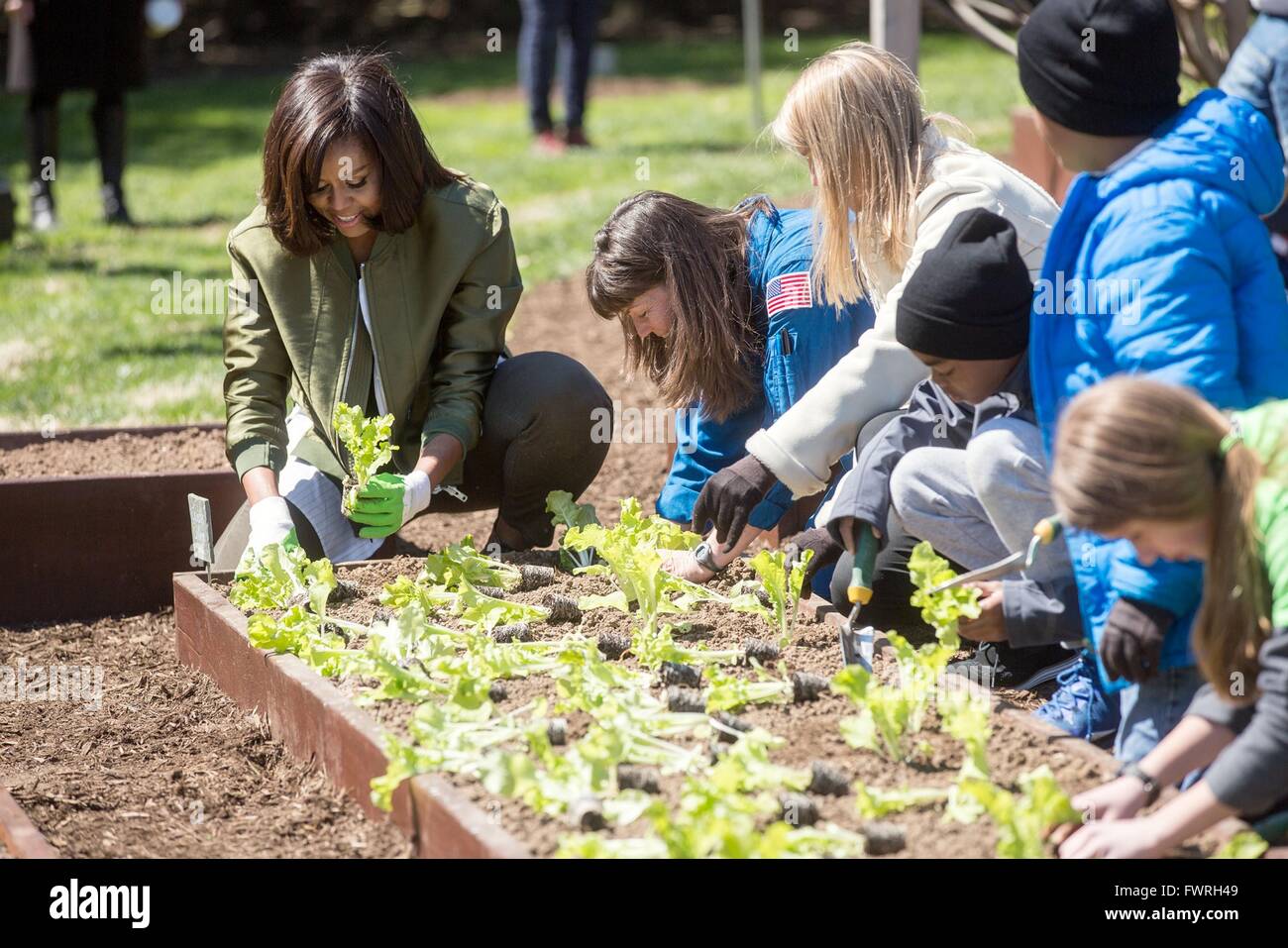 US-Präsidentengattin Michelle Obama zusammen mit Astronaut Cady Coleman und NASA stellvertretender Administrator Dava Newman helfen Schülern, die das Weiße Haus Gemüsegarten Pflanzen 5. April 2016 in Washington, DC. In diesem Jahr der Garten verwendet mehrere Sorten von Gemüse, die auf der internationalen Raumstation angebaut wurden. Stockfoto