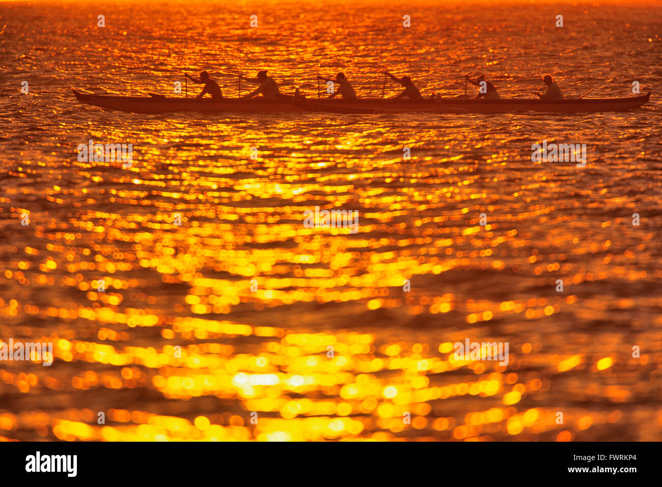 Hawaiian Team paddeln Auslegerkanus bei Sonnenuntergang Maui, Hawaii, USA Stockfoto