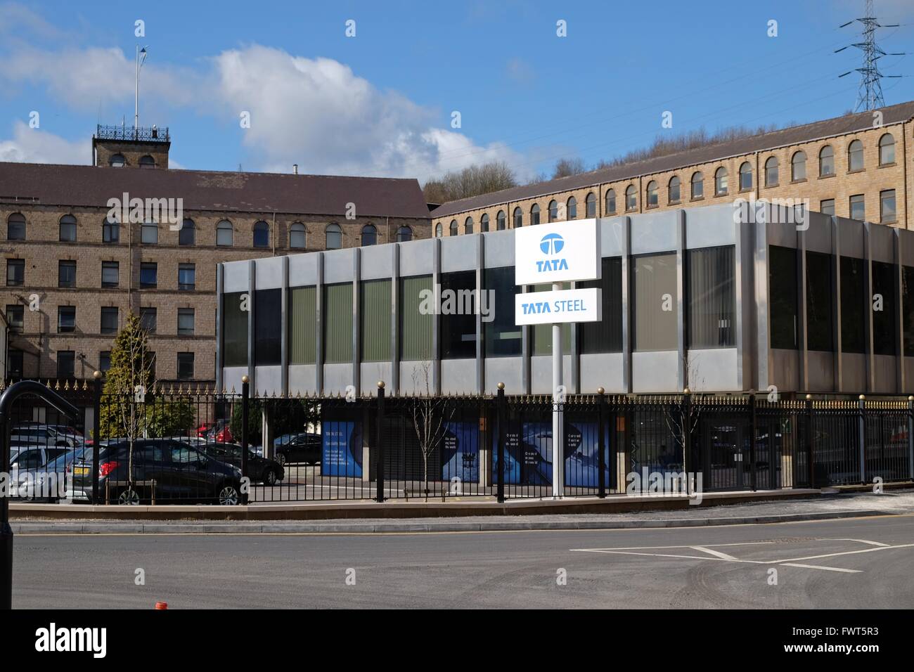 Tata Steel Zeichen außerhalb der Hauptsitz von Stocksbridge, Sheffield Anlage mit alten 19. Jahrhundert arbeitet im Hintergrund Stockfoto