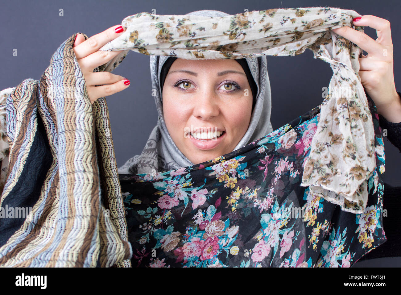 Wunderschöne muslimische Frau, die mit bunten Schals Stockfoto