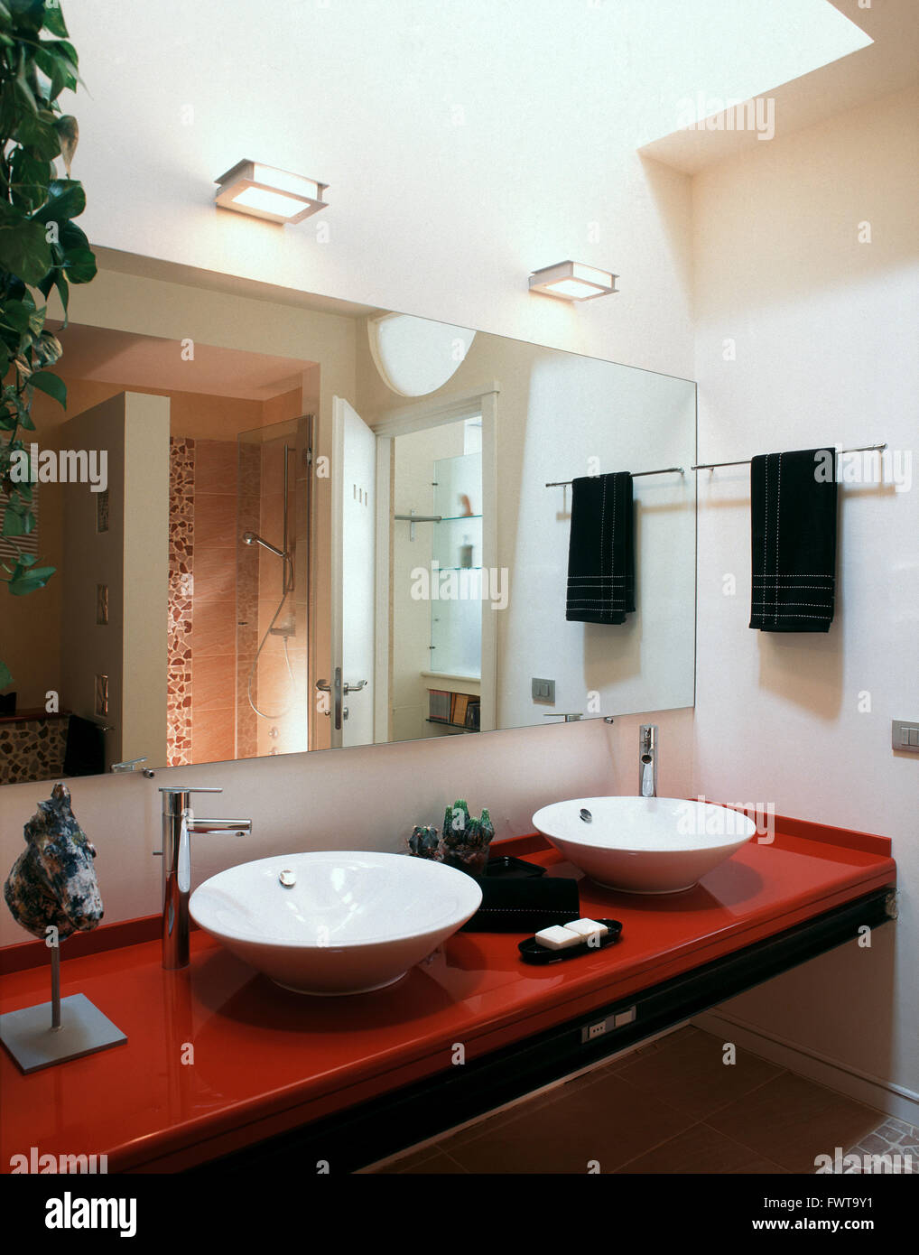 zwei Waschbecken auf der rote Arbeitsplatte im modernen Bad Stockfoto