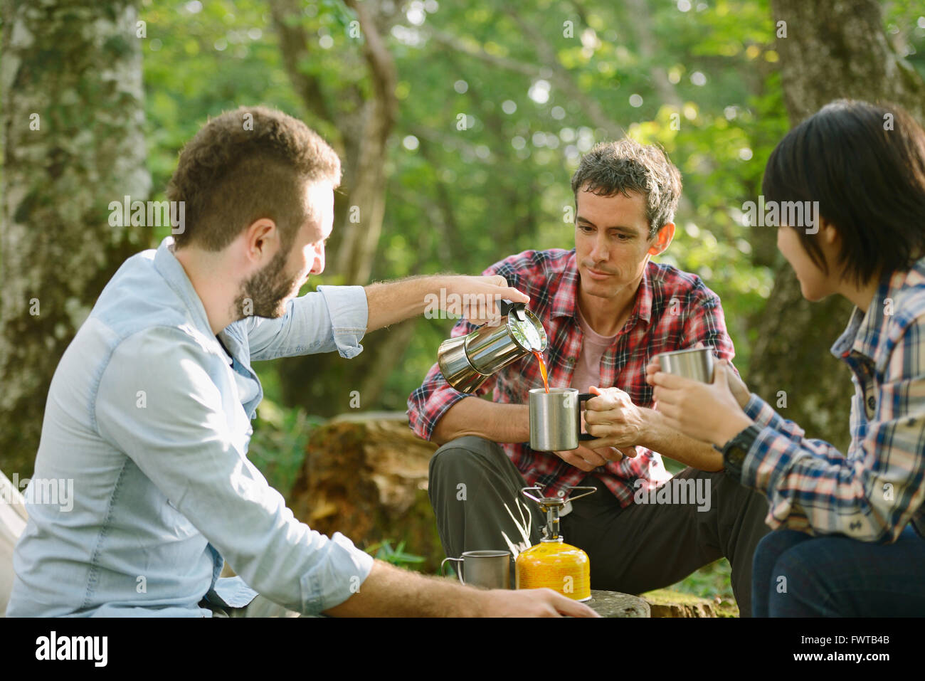 Multi-ethnischen Gruppe von Freunden Kaffeetrinken auf einem Campingplatz Stockfoto