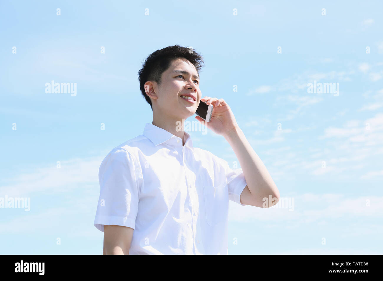 Japanische junge Mann am Telefon am Meer Stockfoto