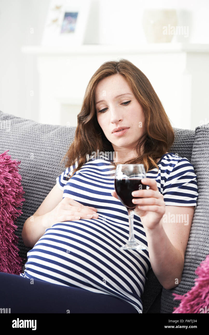 Betroffene Schwangere trinken Rotwein Stockfoto