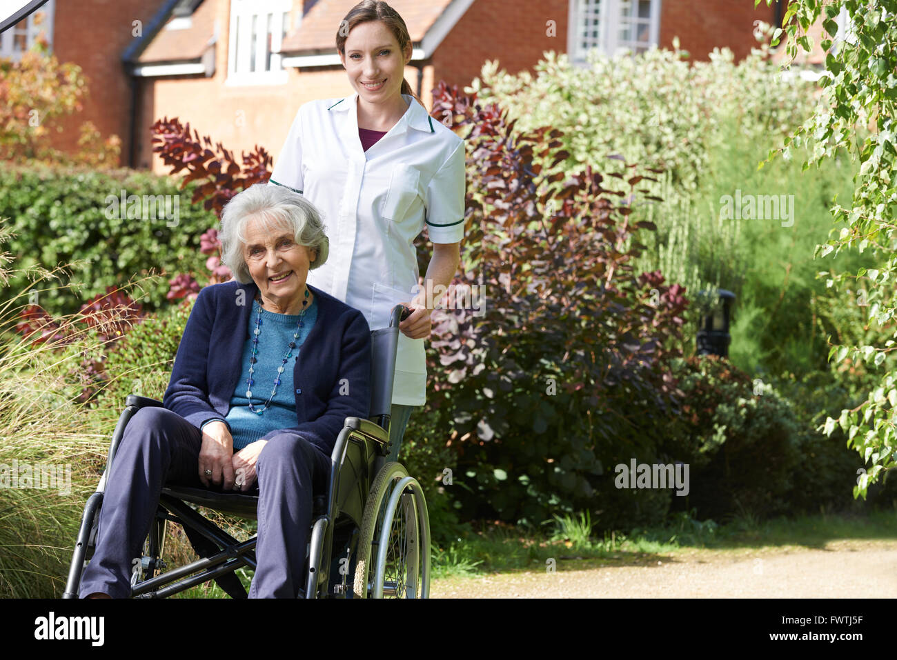 Porträt der Pflegeperson Senior Frau im Rollstuhl schieben Stockfoto
