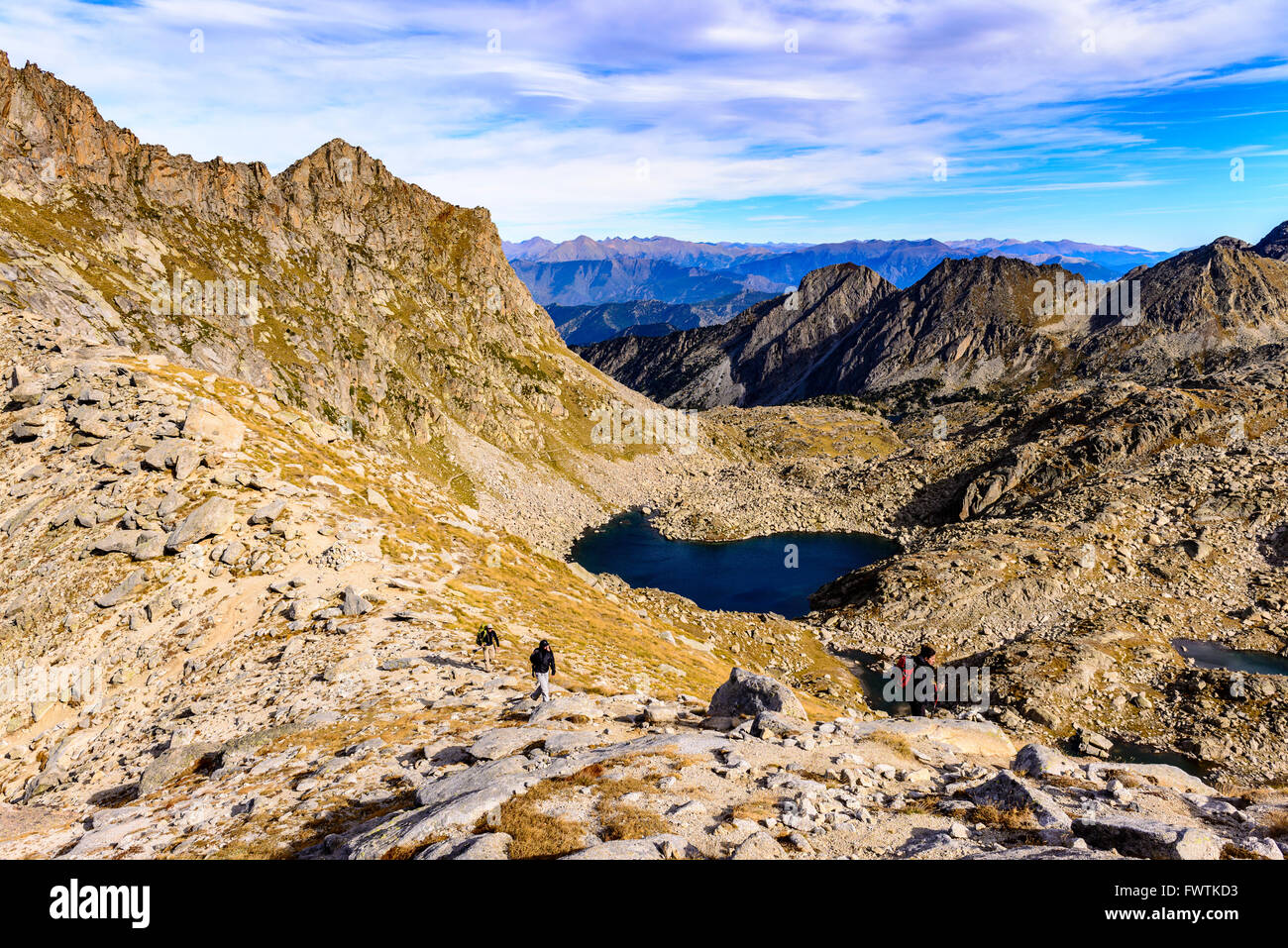 Wanderer Fuß entlang einer Kante mit Bergen und einem See im Hintergrund. Stockfoto