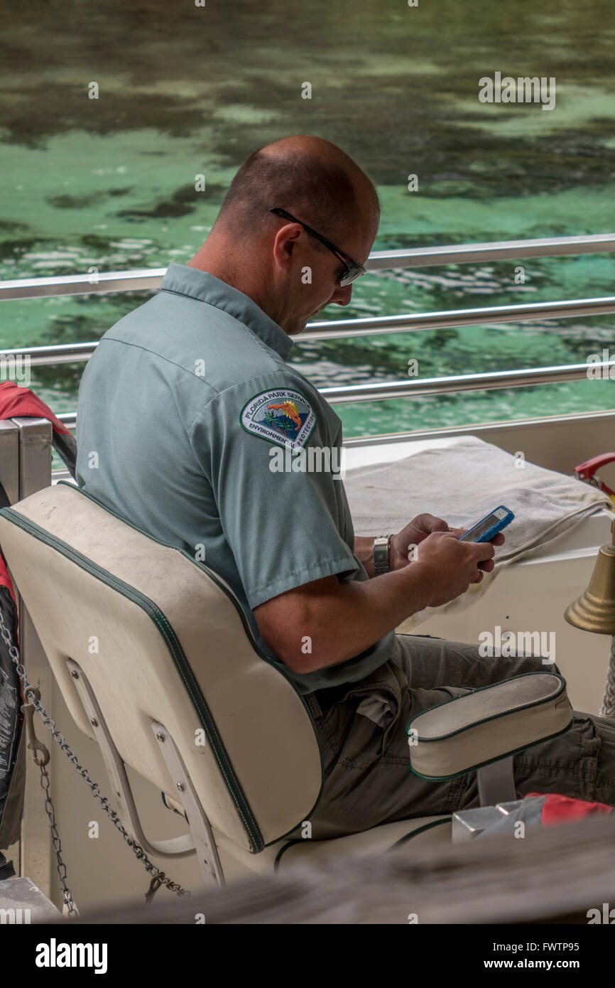 Ein Florida State Park Ranger sitzt auf einem Boot In Weeki Wachee Springs State Park, die Touristen am Fluss Weeki Wachee Stockfoto