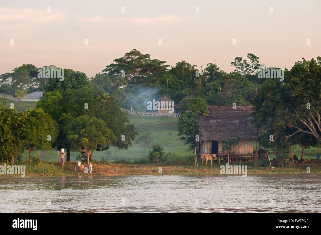Amazonas-Regenwald: Expedition mit dem Boot entlang des Amazonas-Flusses in der Nähe von Iquitos, Loreto, Peru. Navigation einer der Nebenflüsse des Amazonas nach Iquitos etwa 40 Kilometer in der Nähe der Stadt von Indiana. Gruppierten kleine Hütten am Rand einer der Nebenflüsse des Amazonas Stockfoto