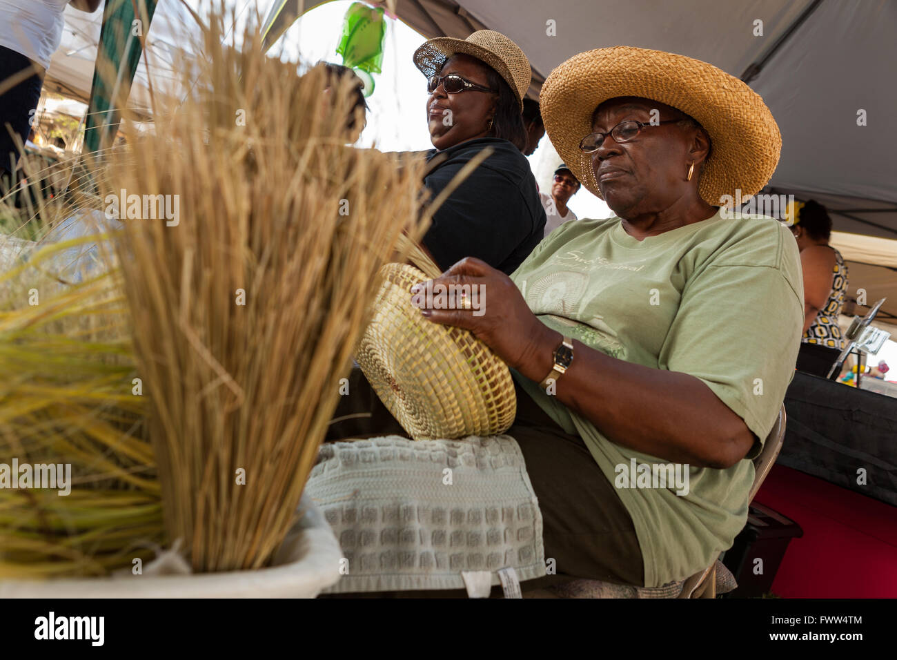 Gullah Frauen Weben Sweetgrass Stroh Körbe in der Tradition ihrer Vorfahren Sklaven aus Westafrika während der Gullah Festival in Mount Pleasant, South Carolina. Gullah Kultur und Sprache auch bekannt als Meer Insel Kreolisch Englisch im isolierten Küsteninseln der Afro-Amerikaner an South Carolina und Georgia gebildet. Stockfoto