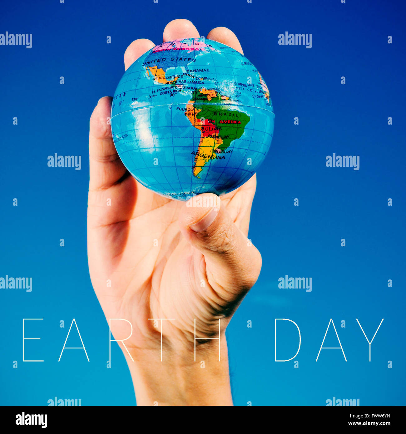 Closeup von einem kaukasischen Jüngling mit einer Weltkugel in der Hand und den Text Earth day Stockfoto