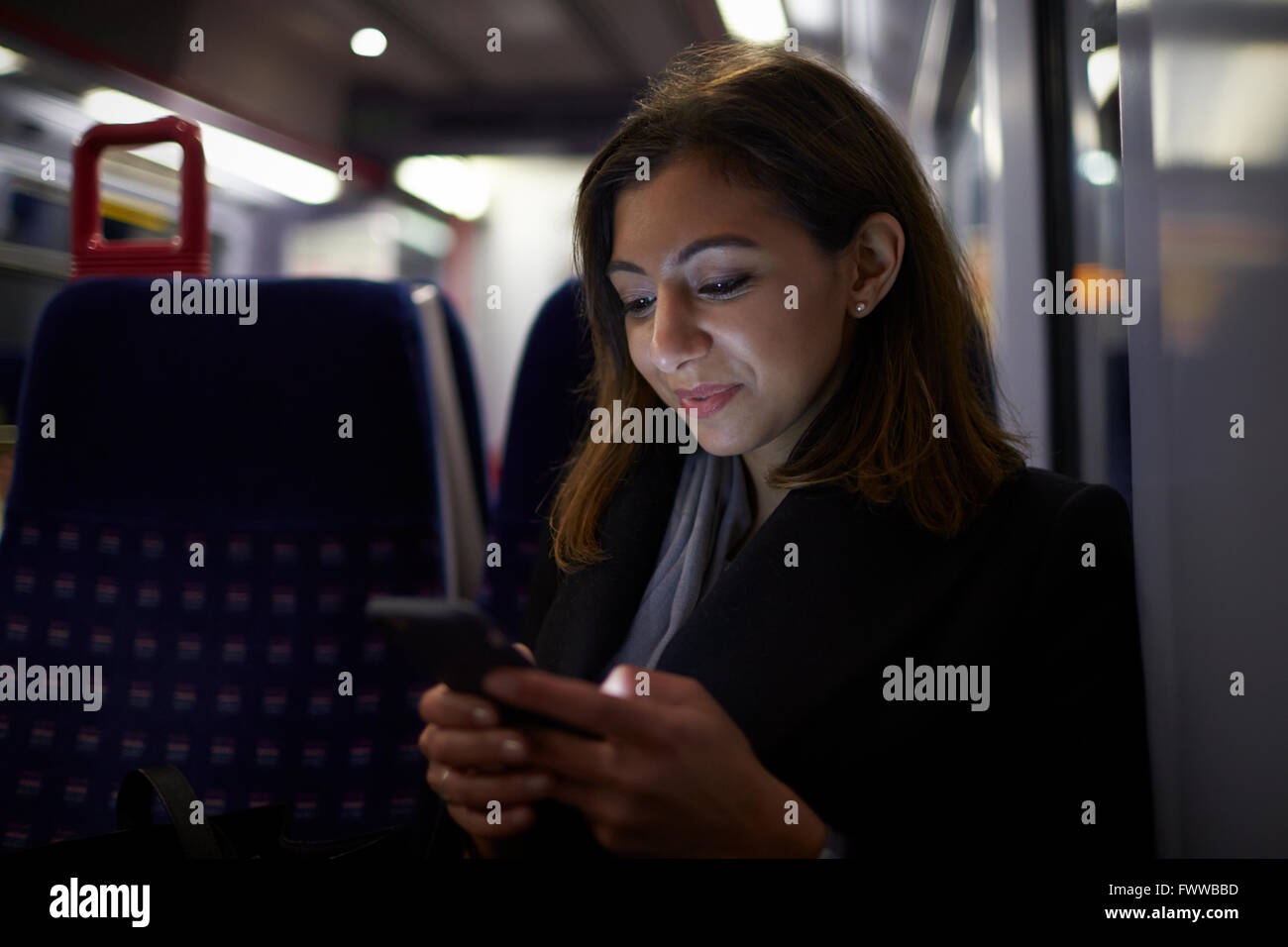Frau sitzt im Zug Wagen senden SMS Stockfoto