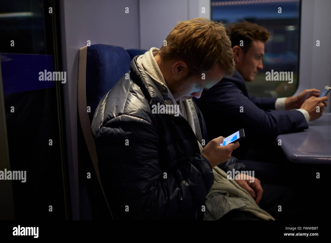 Mann sitzt im Zug Wagen senden SMS Stockfoto