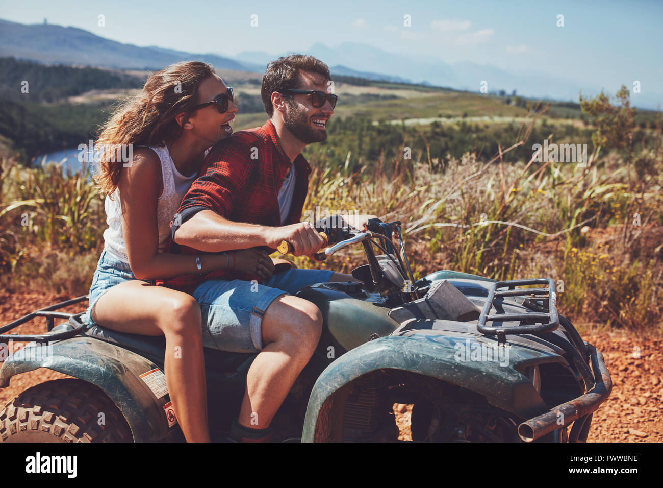 Mann und Frau, die Spaß an einem off-Road Abenteuer. Paar, Reiten auf einem Quad-Bike auf Land an einem Sommertag. Stockfoto