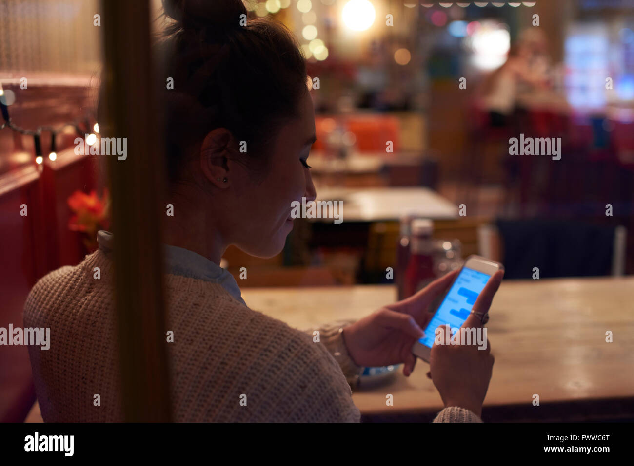 Junge Frau sitzt im Café lesen SMS Stockfoto