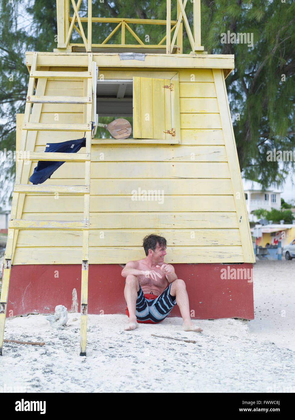 Weißer Mann vor lebensrettende Aussichtsturm am Strand Stockfoto