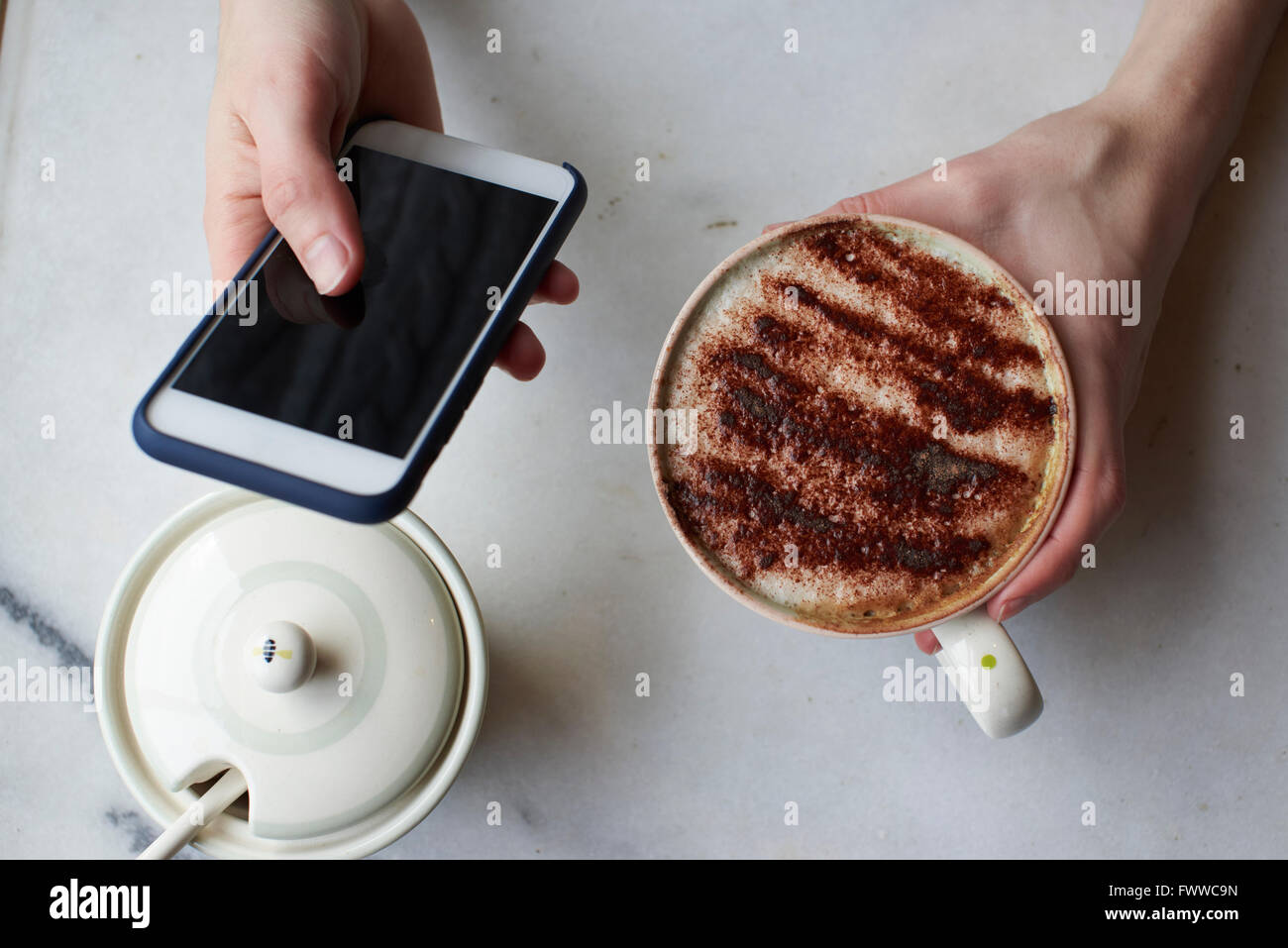 Frau, SMS und trinken Cappuccino Stockfoto