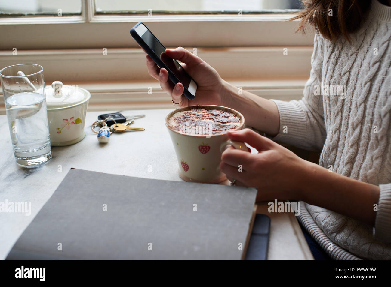 Frau, SMS und trinken Cappuccino Stockfoto