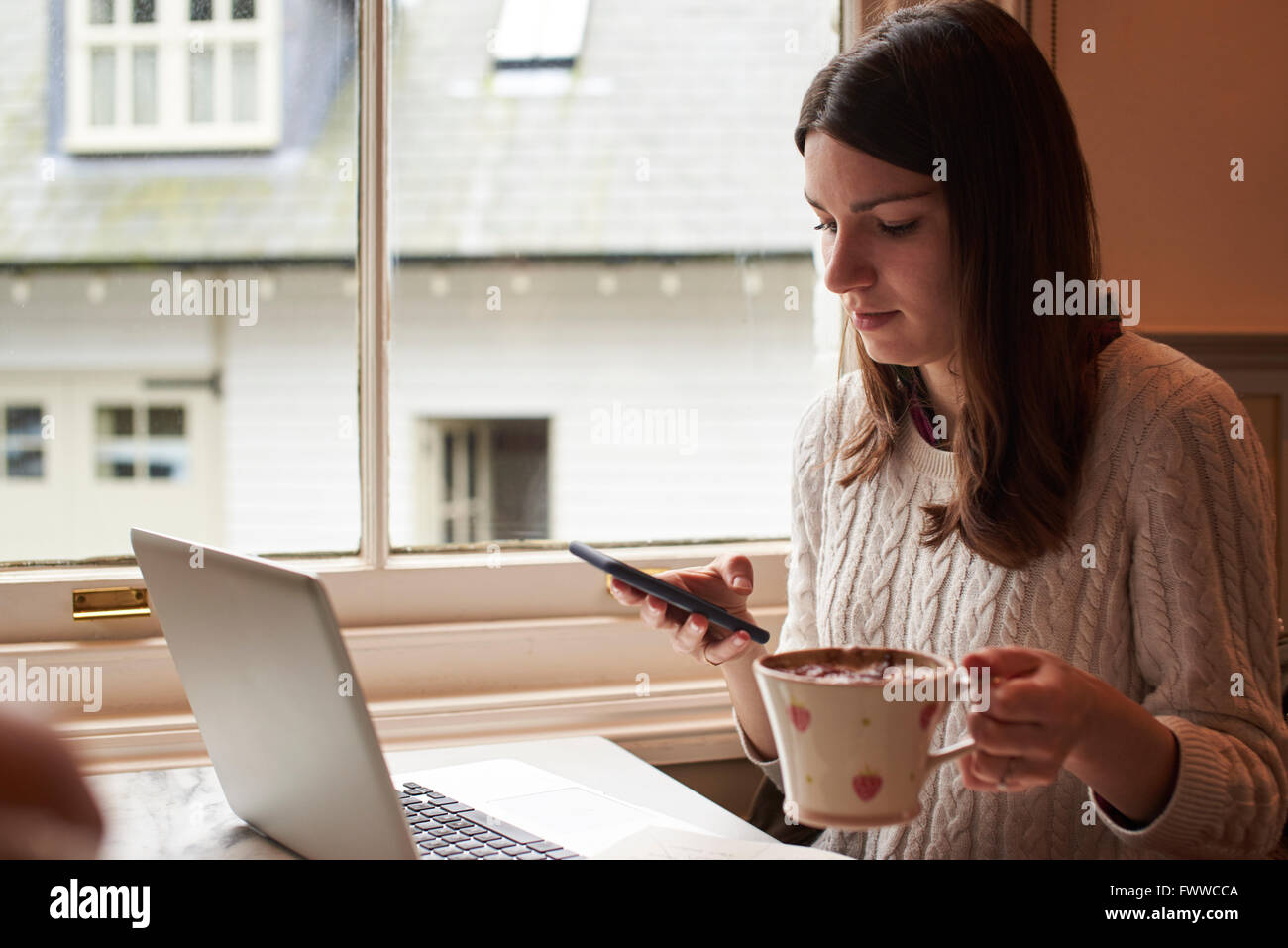 Junge Frau, die Remote arbeiten, vom Café Stockfoto