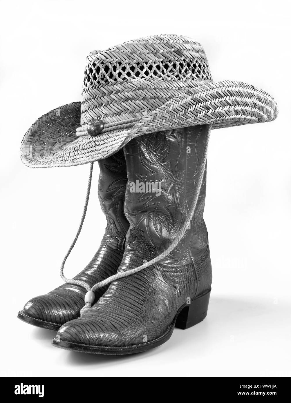 Cowboy-Stiefel und Strohhut in schwarz und weiß. Stockfoto