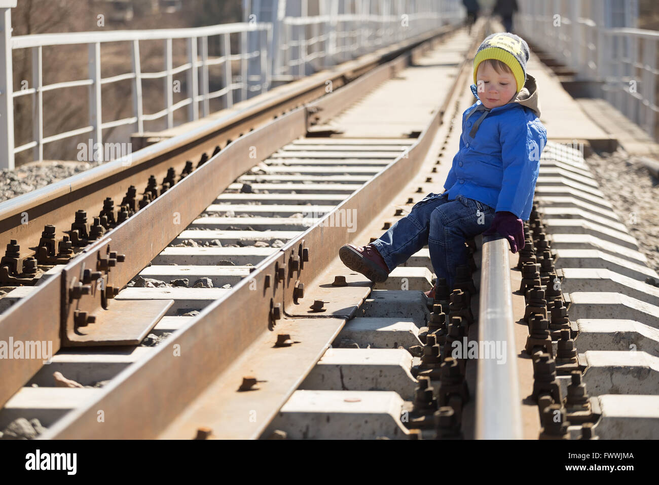Porträt eines kleinen Jungen sitzen auf den Schienen in der Tageszeit. Belarus Stockfoto