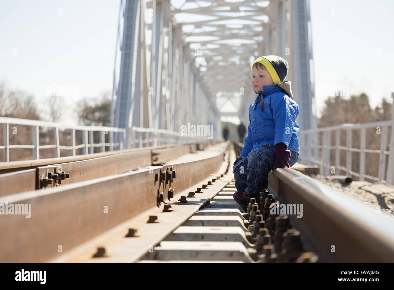 Porträt eines kleinen Jungen sitzen auf den Schienen in der Tageszeit. Belarus Stockfoto