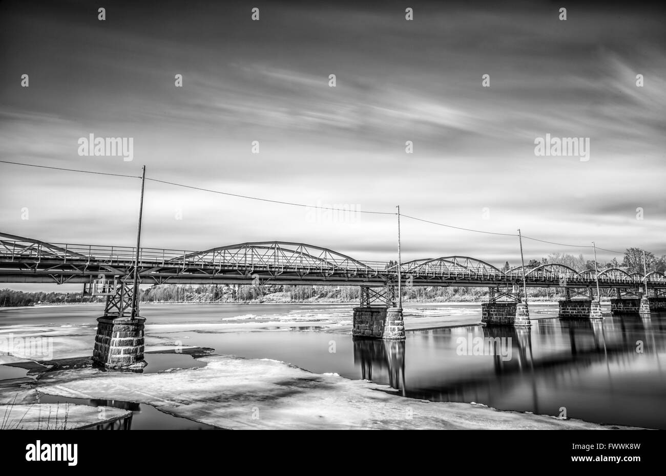 Brücke über die Umeå, Fluss in Schweden mit Eis und ein bewölkter Himmel Stockfoto