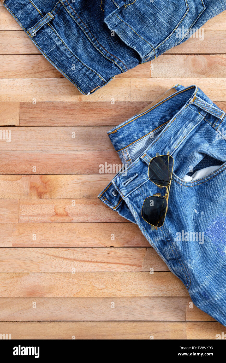 Gebrauchte Jeans und Aviator Sonnenbrille auf Holz Stockfoto