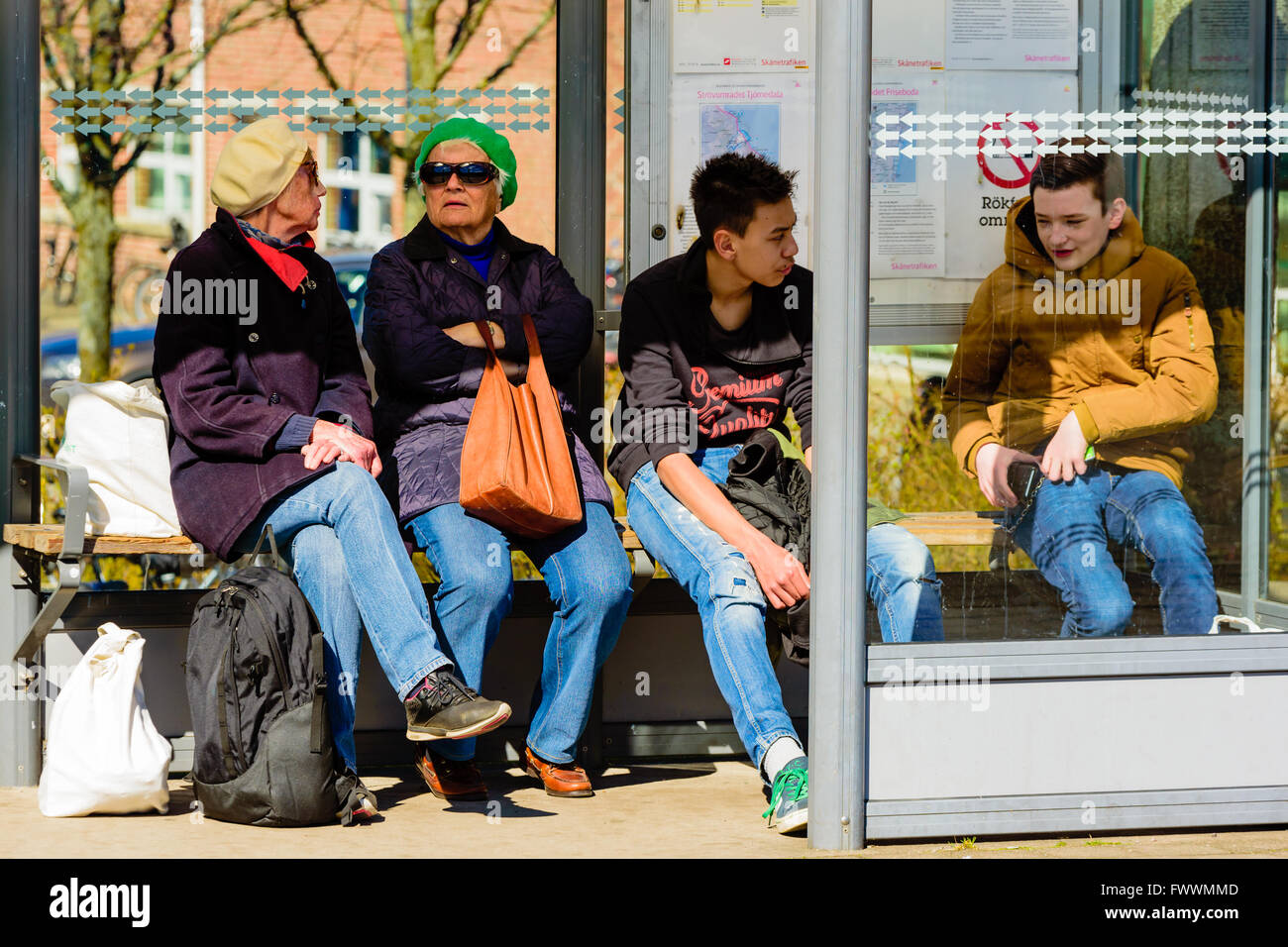 Simrishamn, Schweden - 1. April 2016: Menschen warten auf einen Bus in einer Wartehalle. Echte Menschen im Alltag. Stockfoto