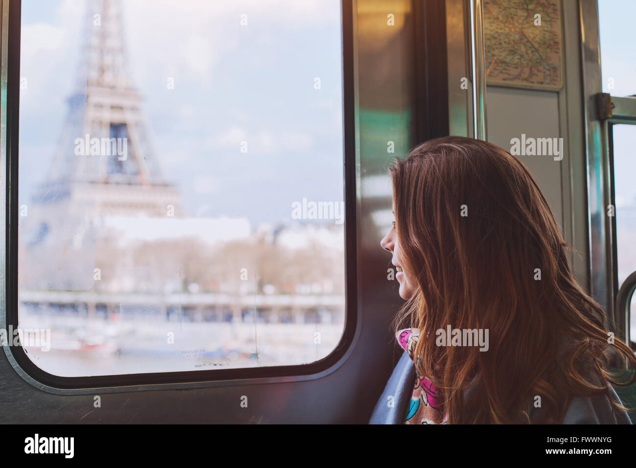Touristen auf der Suche um den Eiffelturm durch das Fenster der Metro in Paris, lächelndes Mädchen besuchen Frankreich Stockfoto