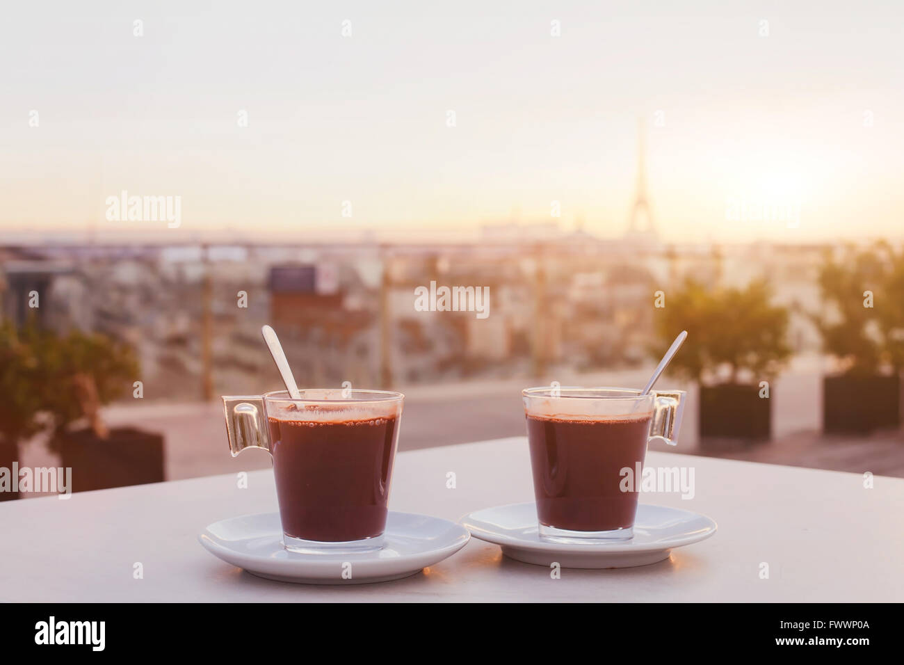 zwei Tassen Kaffee oder heiße Schokolade und Paris Skyline bei Sonnenuntergang, Café mit Panoramablick über die Stadt mit Eiffelturm Stockfoto