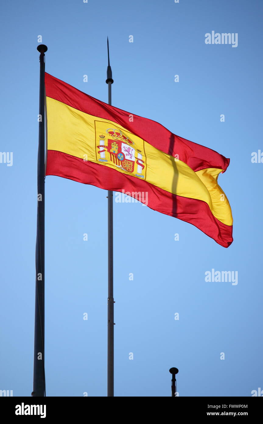 Spanische rote, gelbe und rote Fahne flattert im Wind Stockfoto