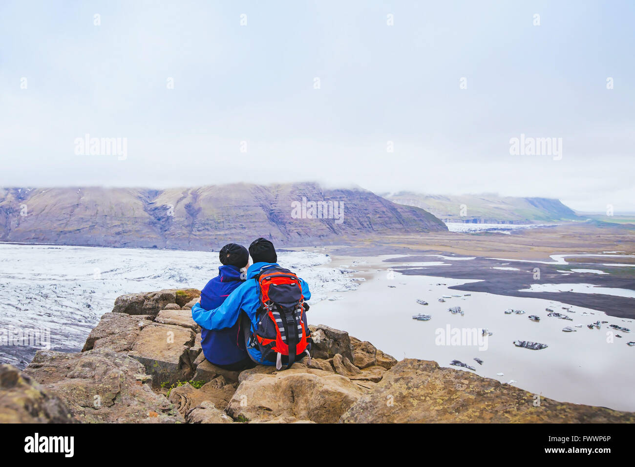 paar Wanderer Reisen in Island, zwei Rucksacktouristen, die Aussicht auf Gletscher und Berglandschaft Stockfoto